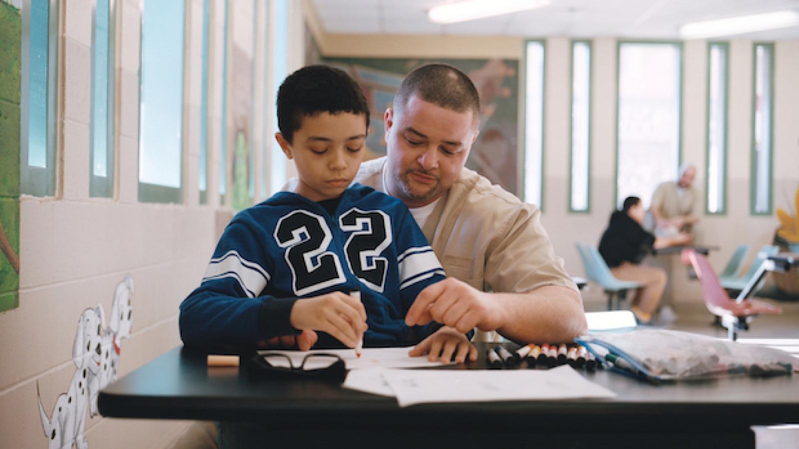a young boy and his father dressed in a prison jumpsuit color together