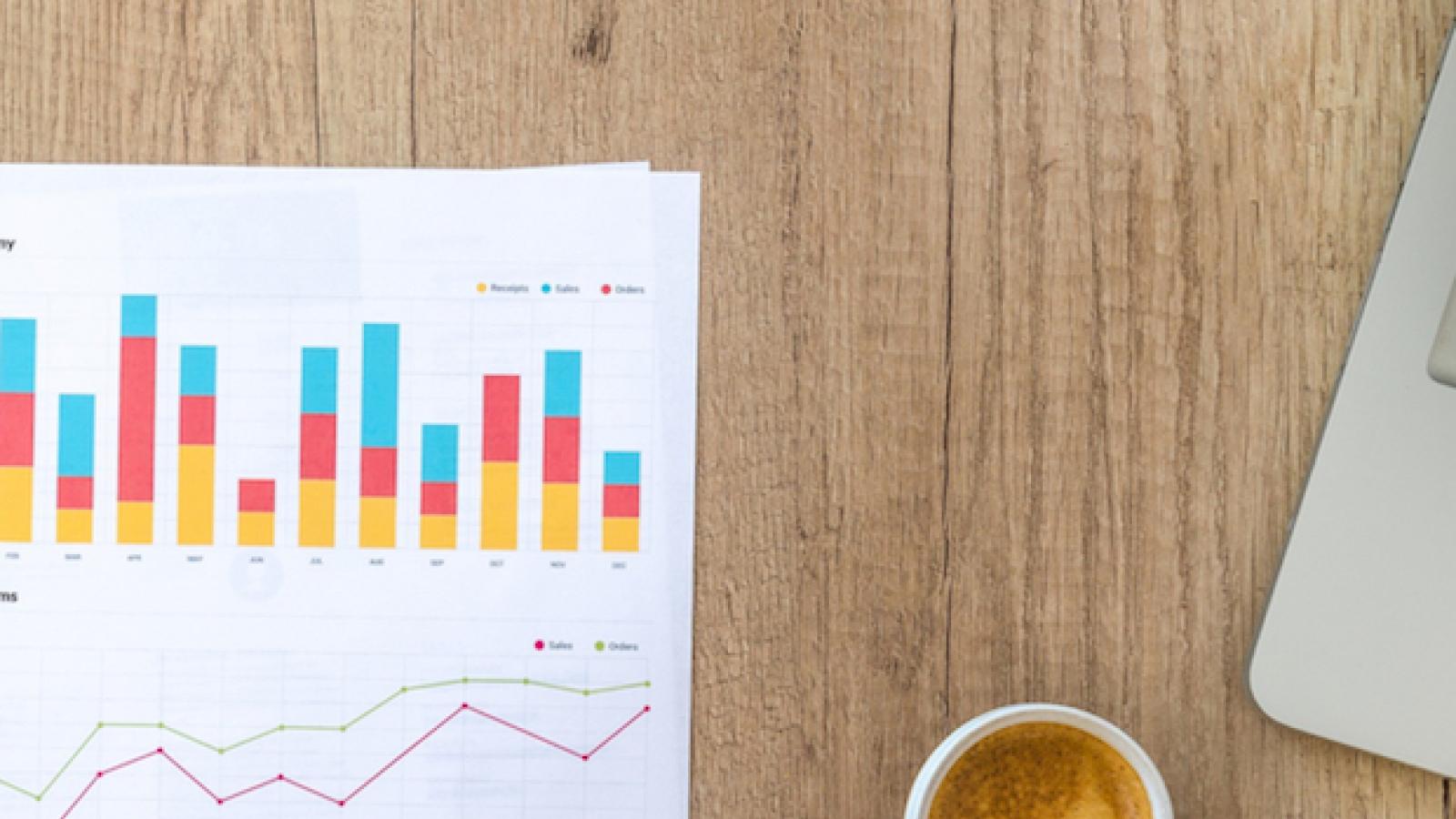 photo of graphs and charts with a cup of coffee and text that reads Taking Note