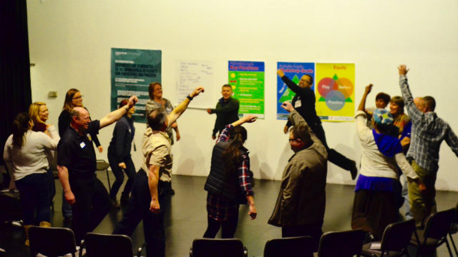 People stand in a circle with raised arms