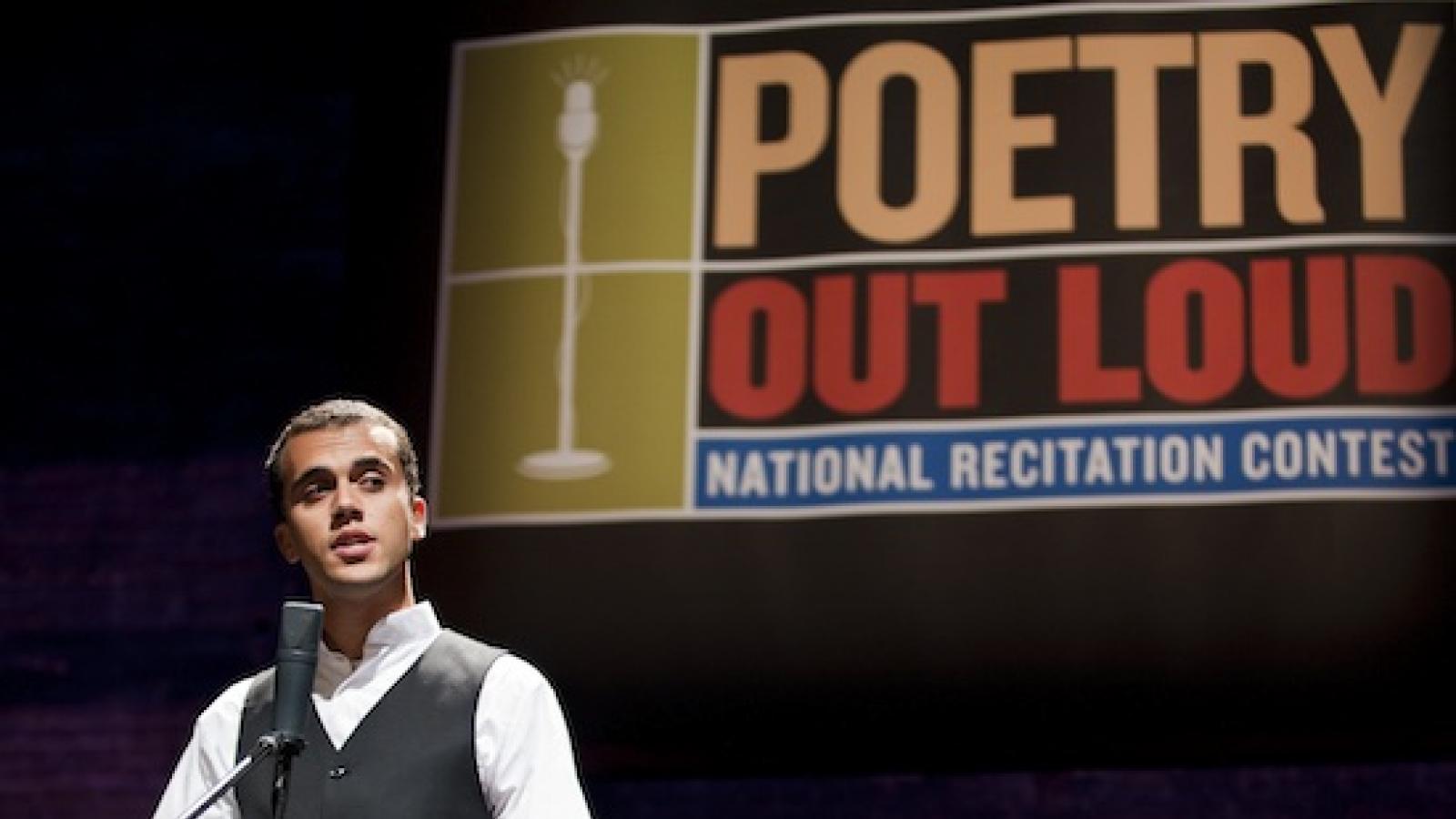 A young man stands behind a microphone mid-performance. A banner saying Poetry Out Loud is visible above his head