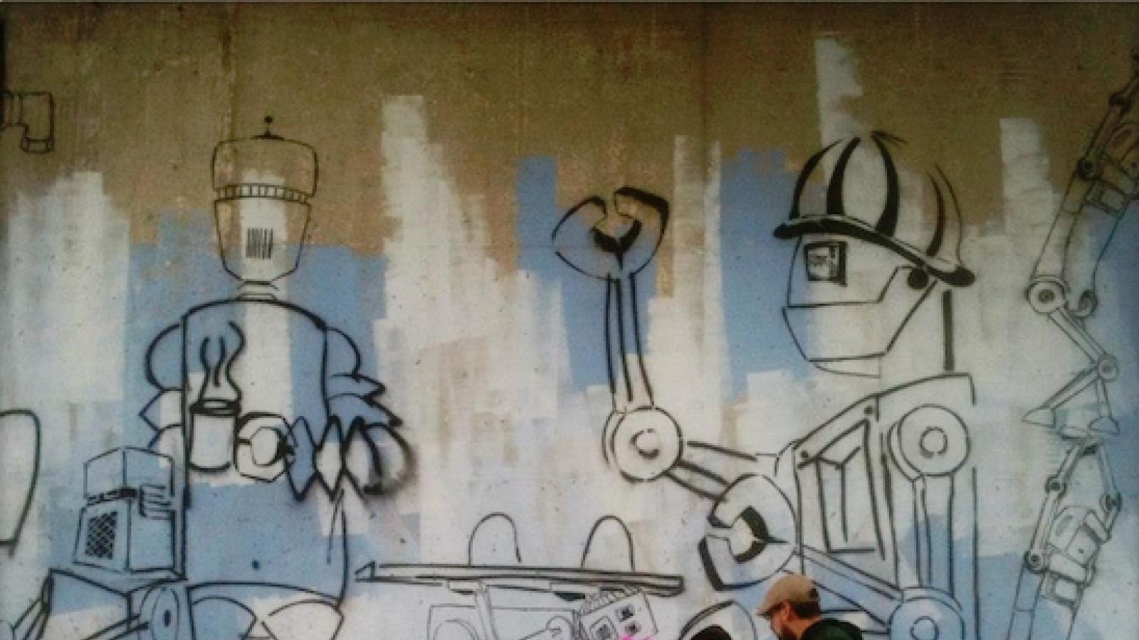 a man and three kids stand in front of the outline of a mural featuring robots 