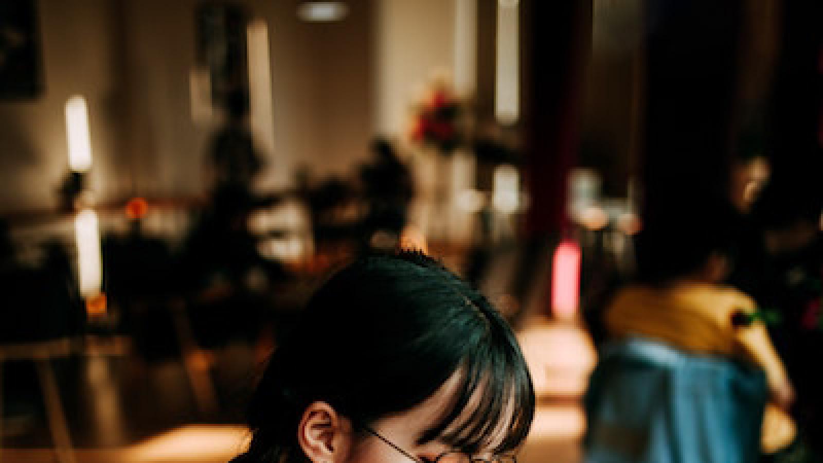 a young woman with glasses reads a book in a cafe