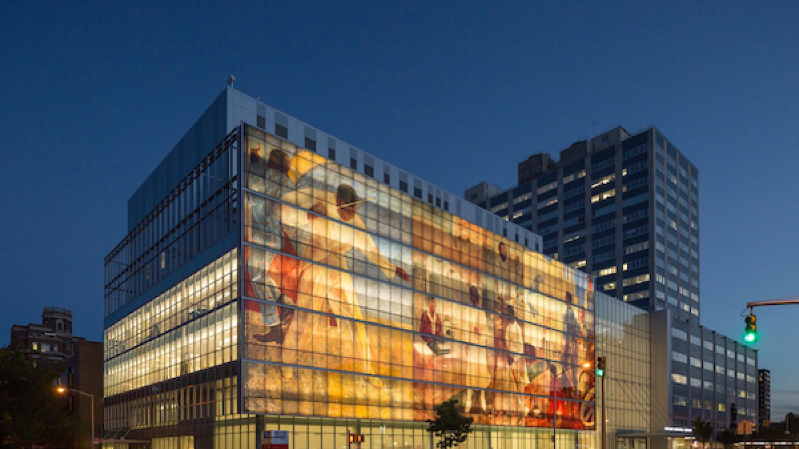 the facade of Harlem Hospital with an image projected on it