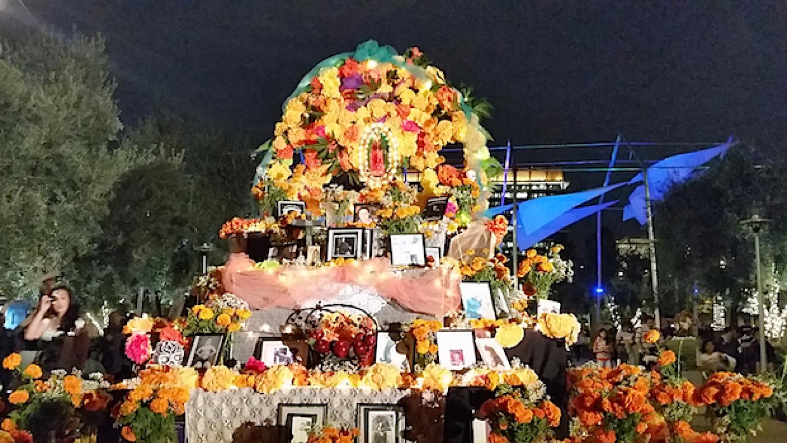A large flower altar in an outdoor setting at night.