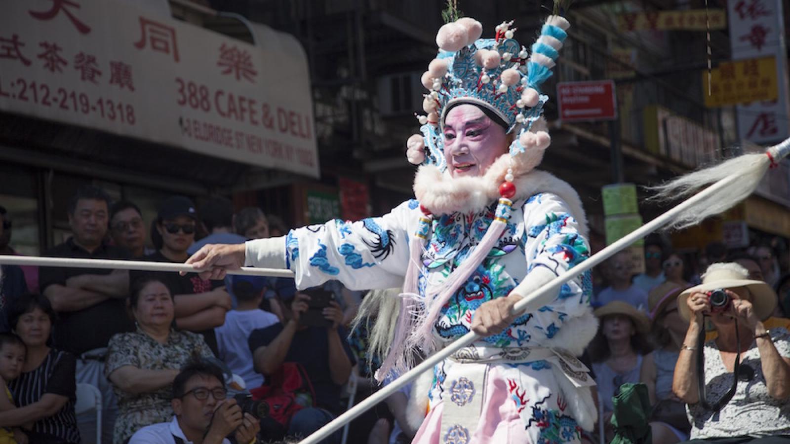 a performer during a parade wears traditional Chinese dress