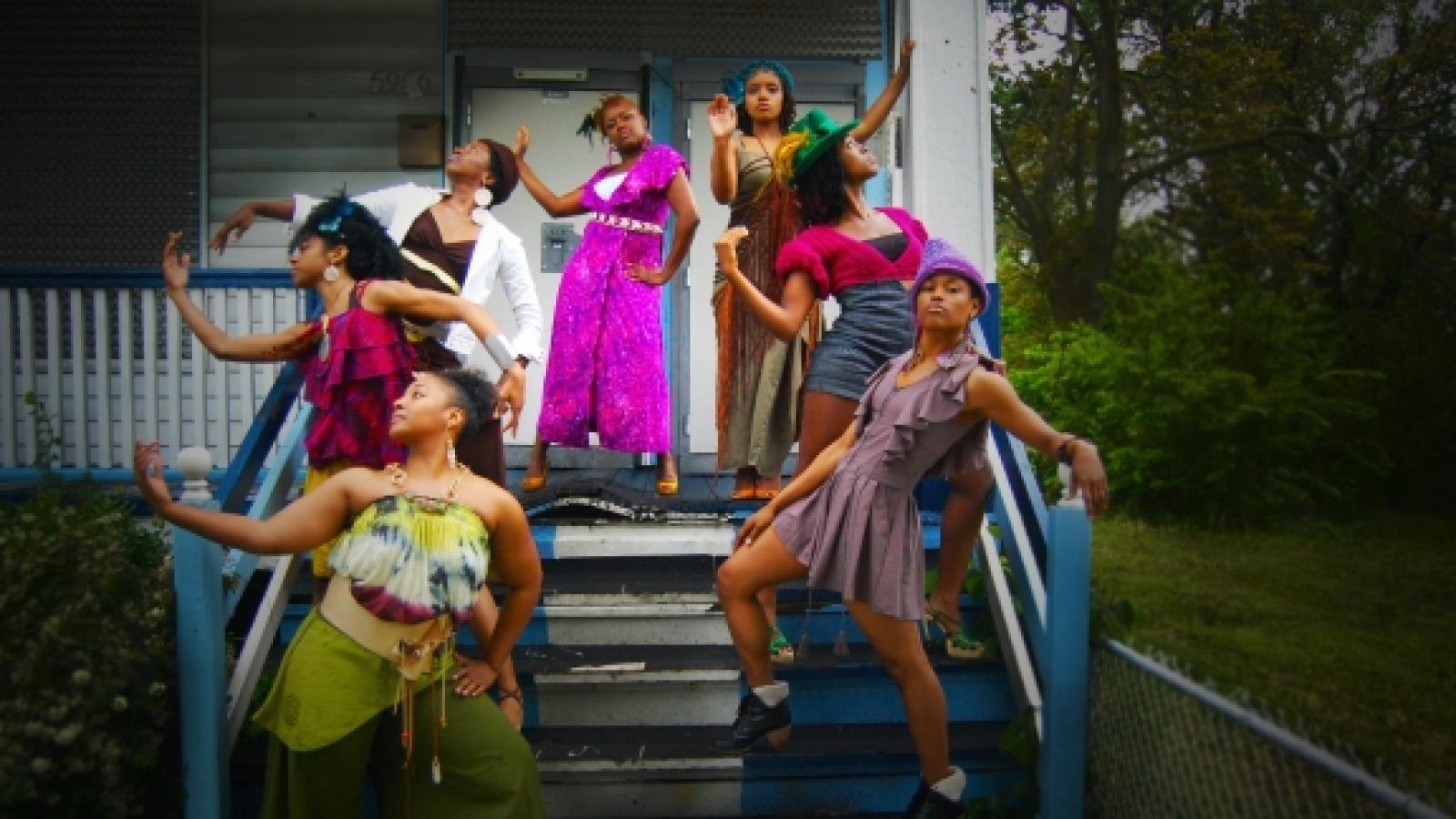 Black women dancers standing on the stairs of a porch.
