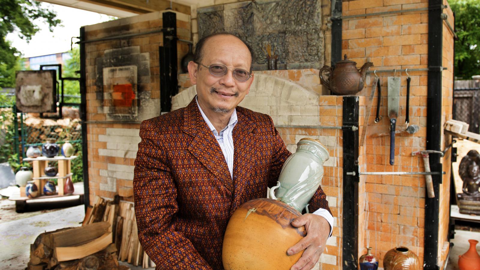 Man holding pottery.