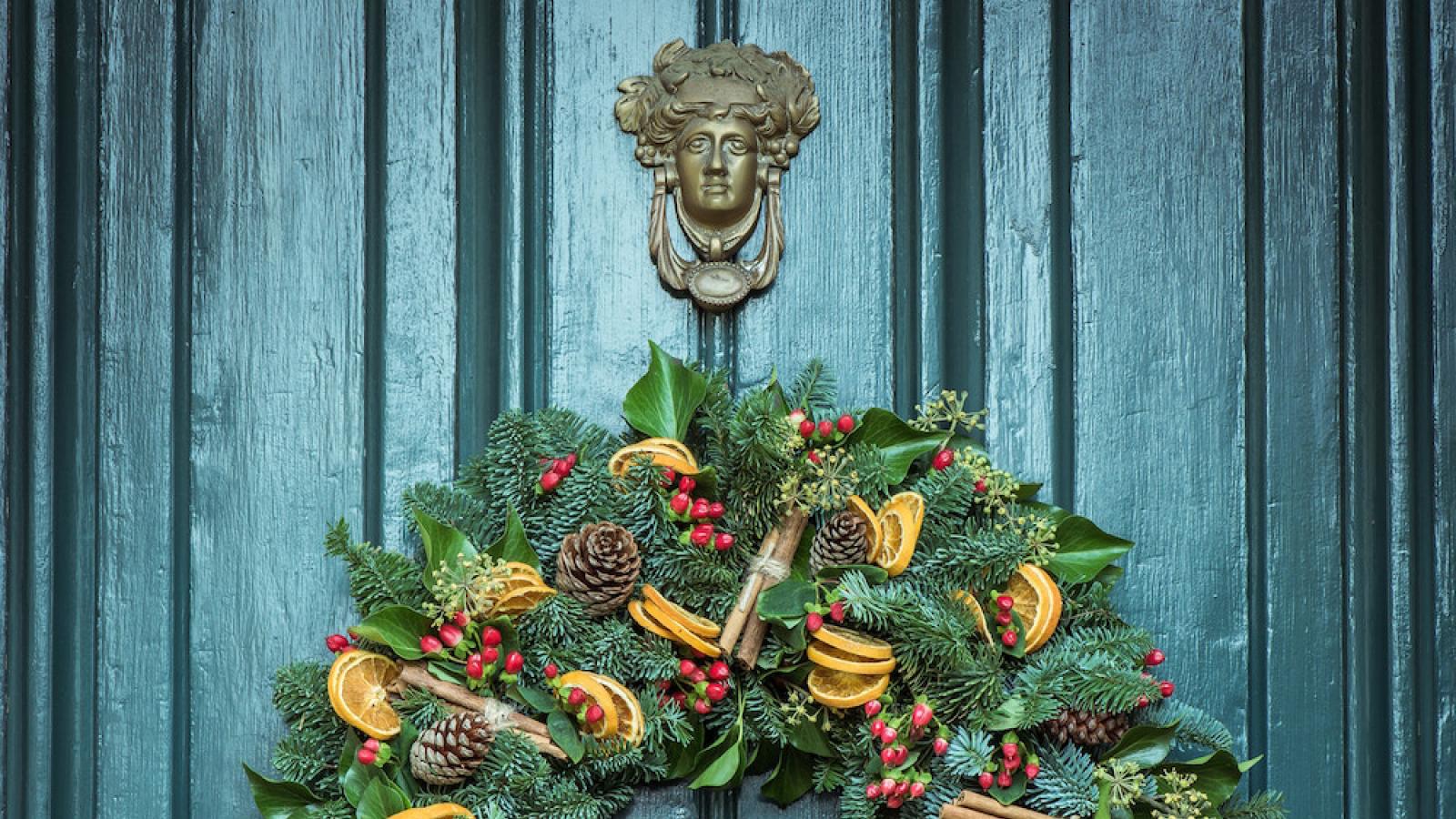 green christmas wreath hanging on green door