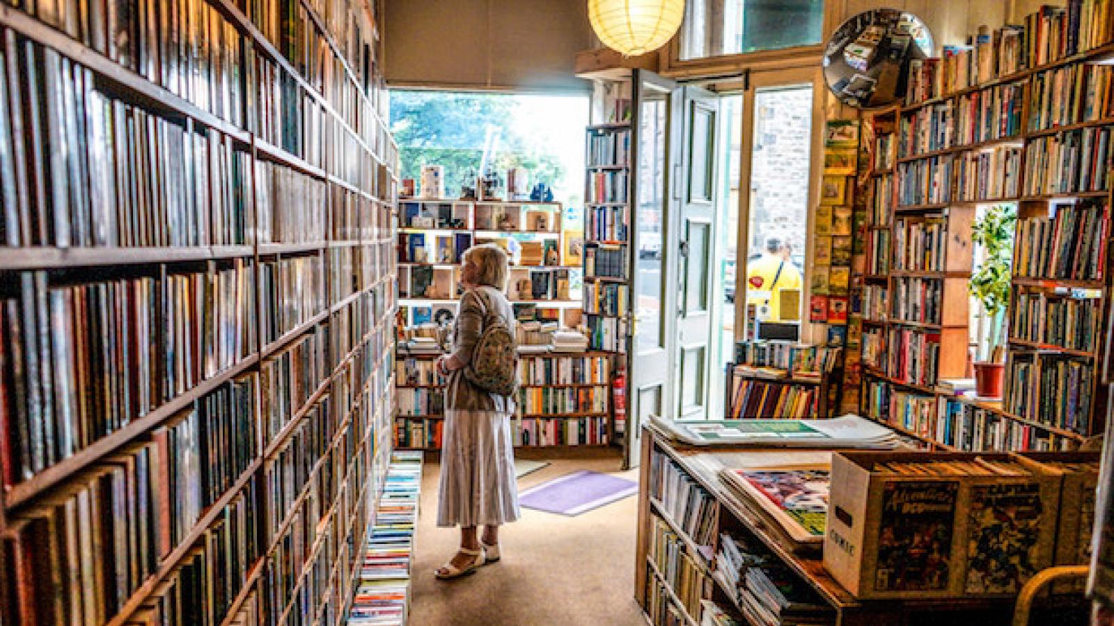 an older woman looking at books in a neighborhood book store