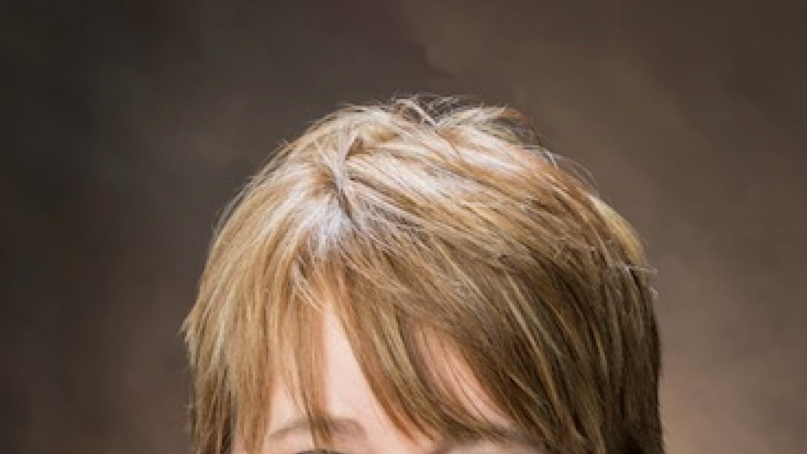 a smiling white woman with short brown hair wearing a collared shirt and necklace