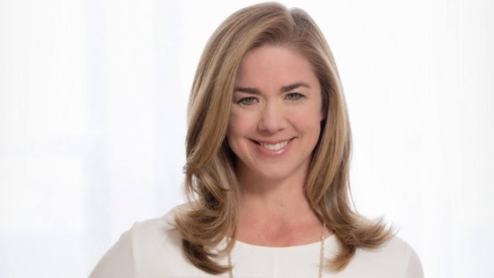 a young white woman with long dark blonde hair in a white blouse