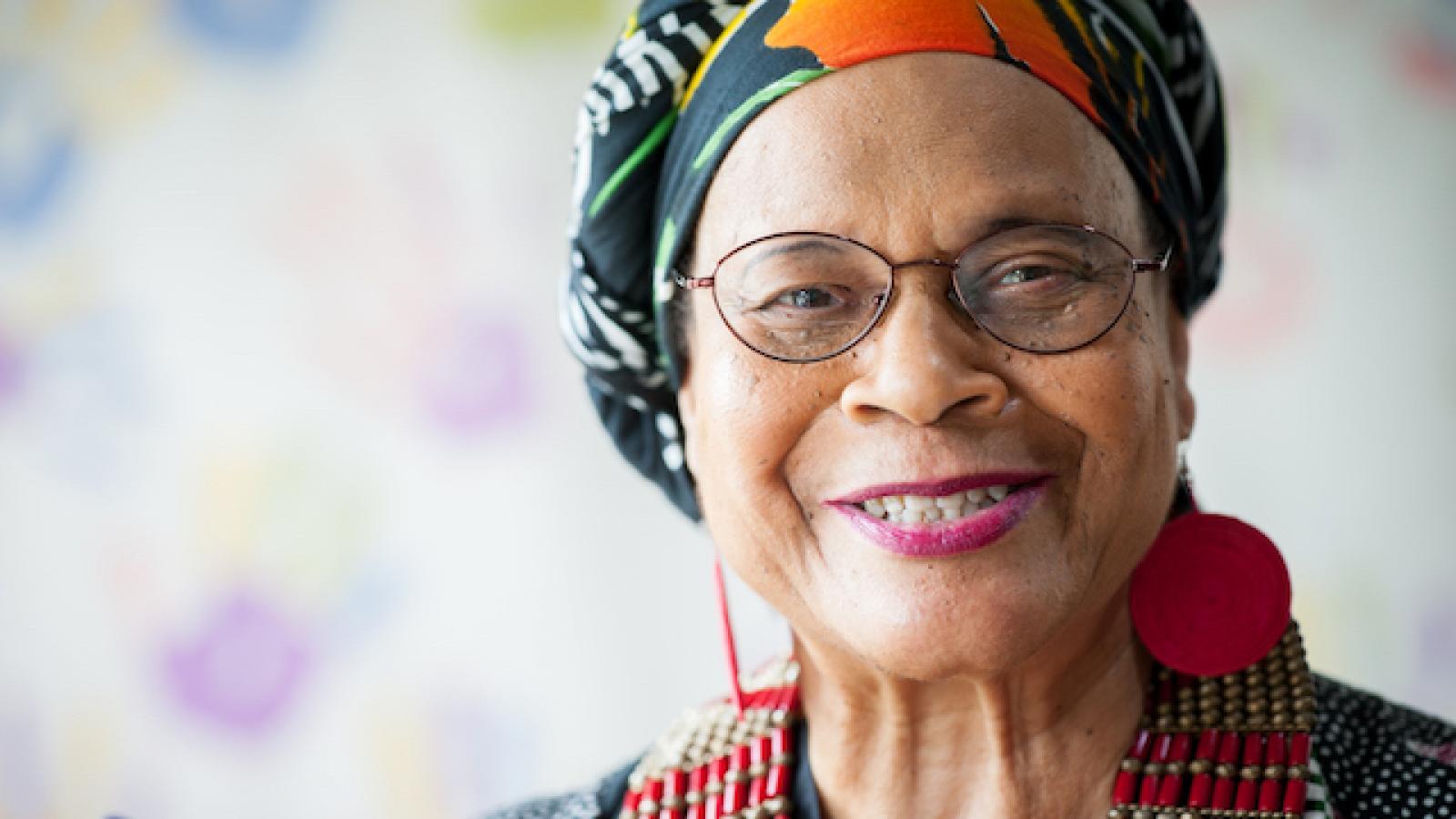 headshot of Linda Goss wearing a colorful headwrap and beaded jewelry