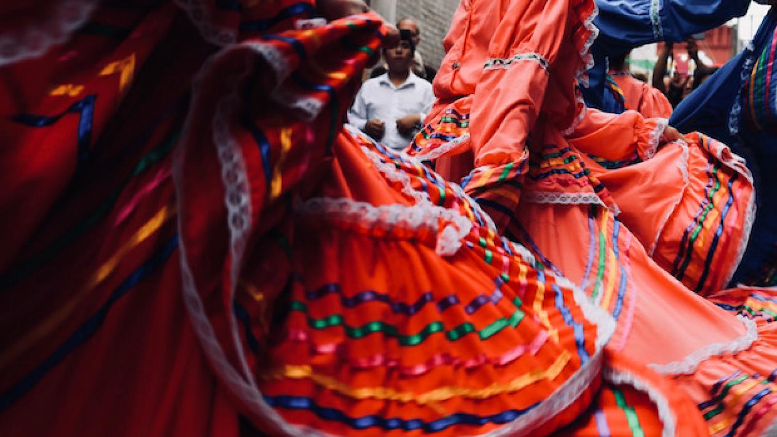 close-up of Latinx dancers in colorful skirts