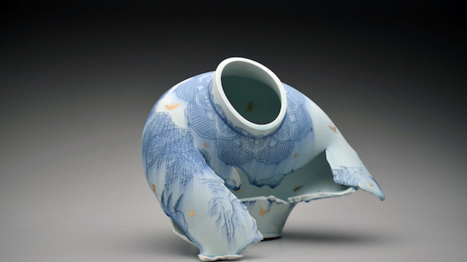 a blue and white ceramics jar that looks like it's ripped apart in the center