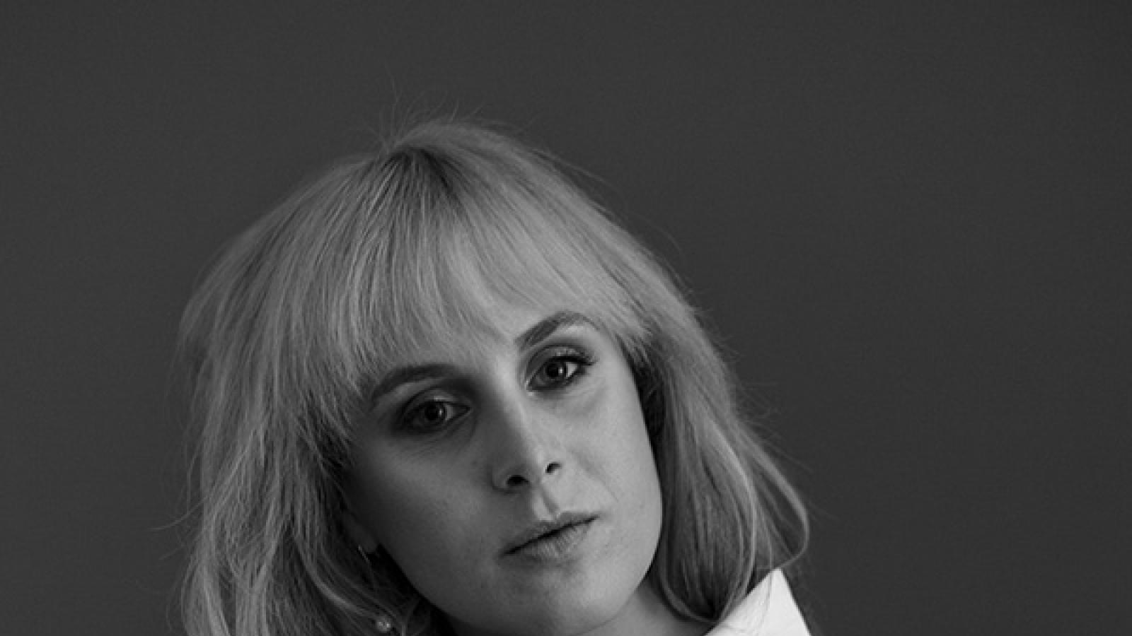 Blonde woman in white shirt sitting on chair
