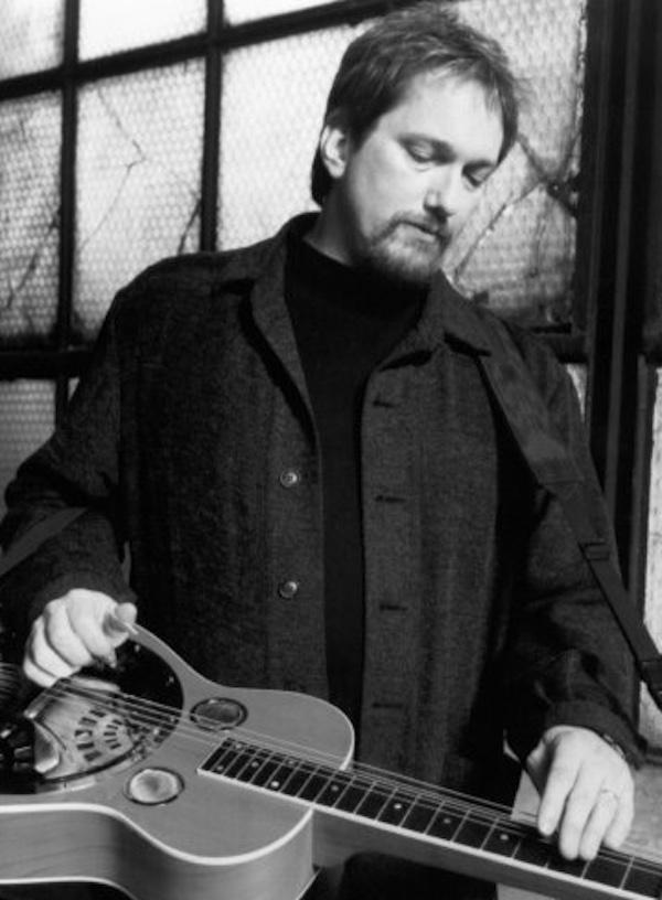 A man holding a guitar.