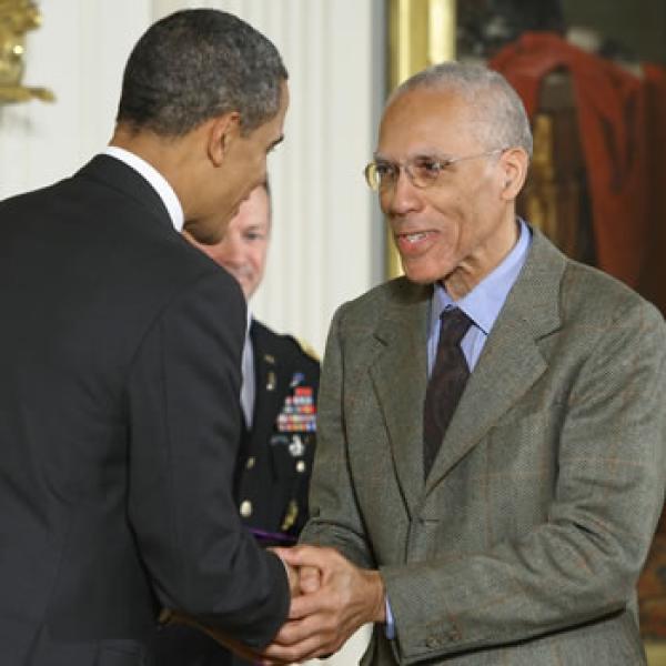 Two men shake hands.