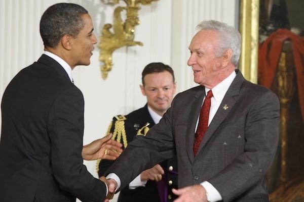 Two men shake hands.