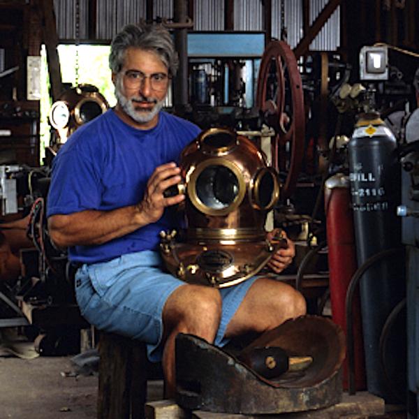 A man holding a divers helmet.