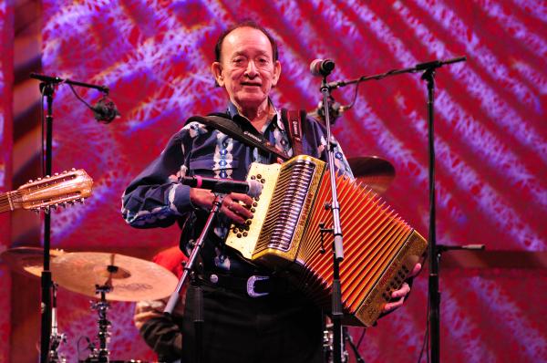 Man on stage playing accordion.