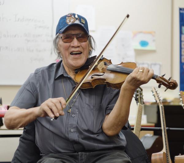 A man plying a fiddle.