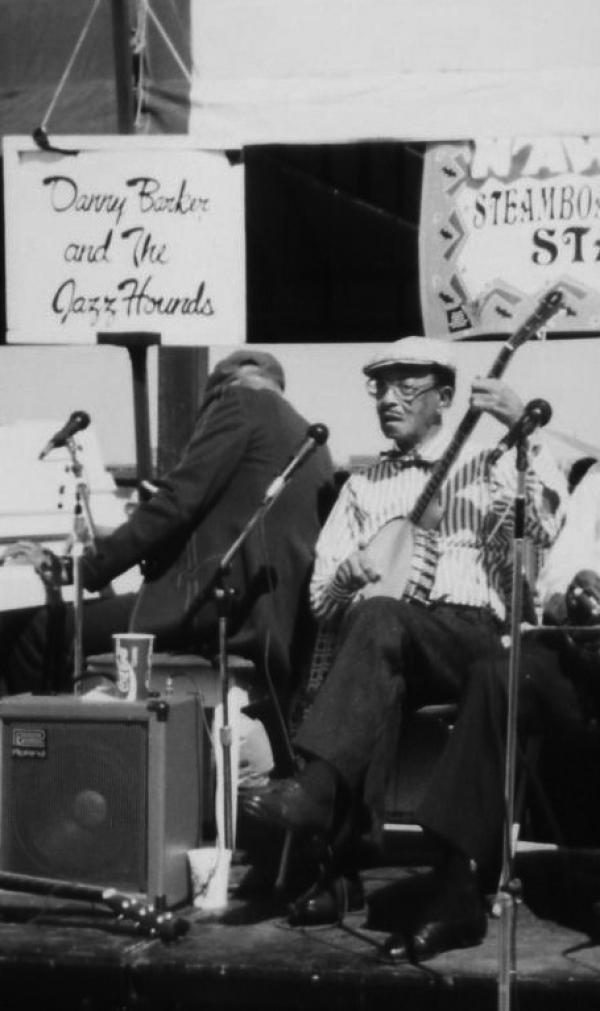 Man playing banjo on stage.