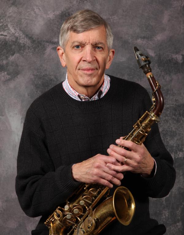 Portrait of man holding saxophone. 
