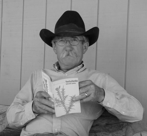 Man in cowboy hat reading a book. 