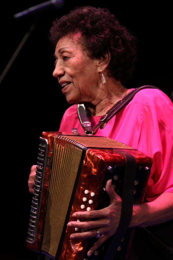 Woman on stage playing an accordion.