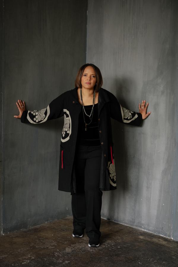 Woman in jacket standing in corner of room