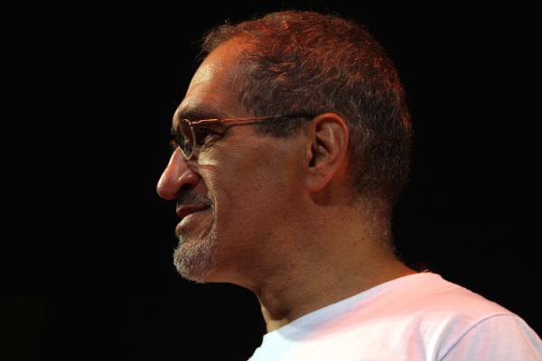 Latino man with short gray hair wearing glasses in profile. 