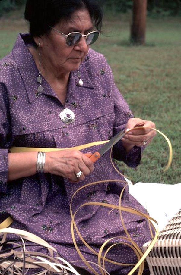 A woman weaving a basket.