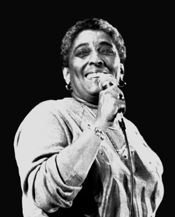 Woman with mic singing. 