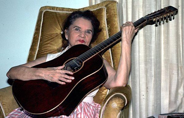 A woman playing a guitar.