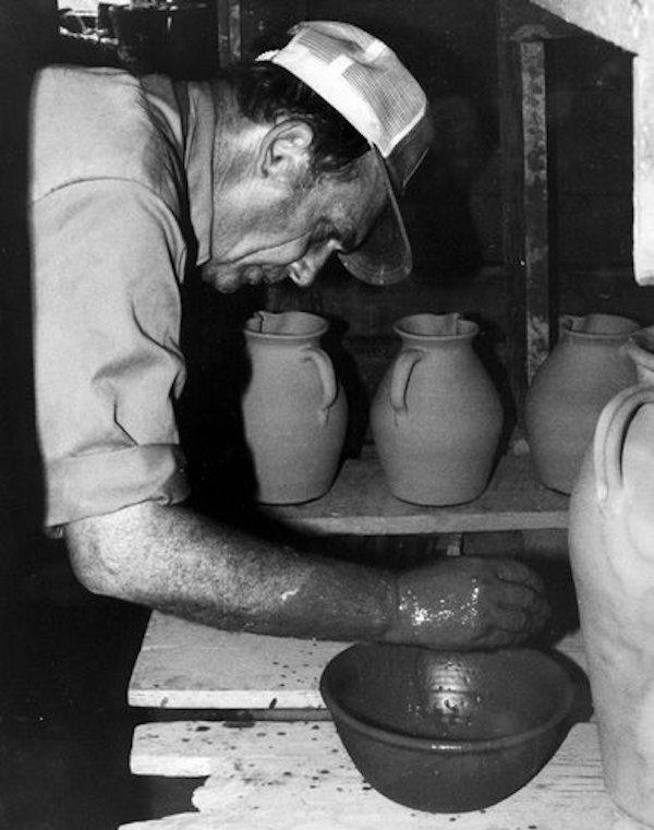 A man shapping a clay pot.