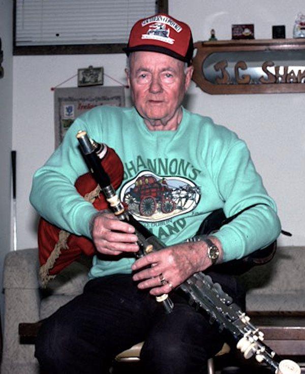A man holding a bag pipe.