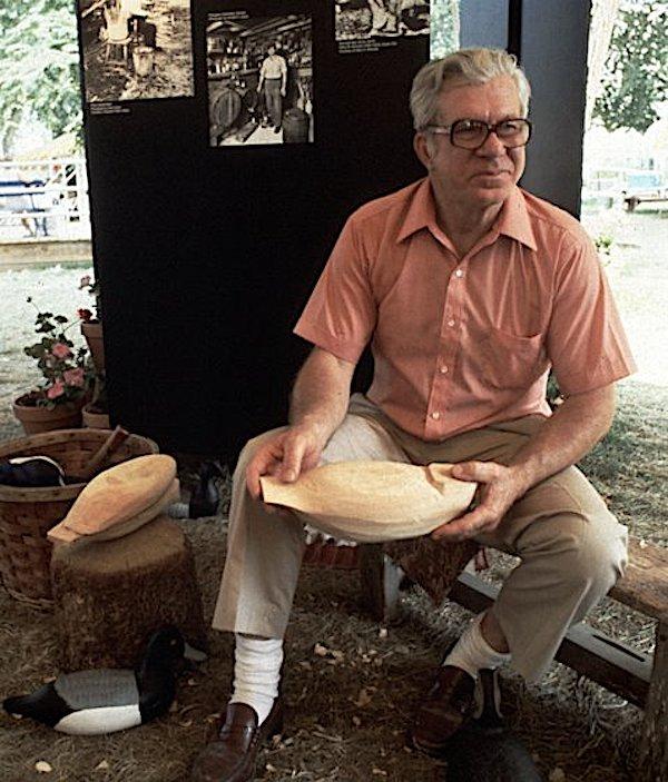 A man holding a wooden decoy.
