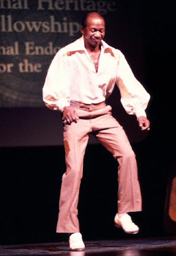 A man tap dancing on a stage.