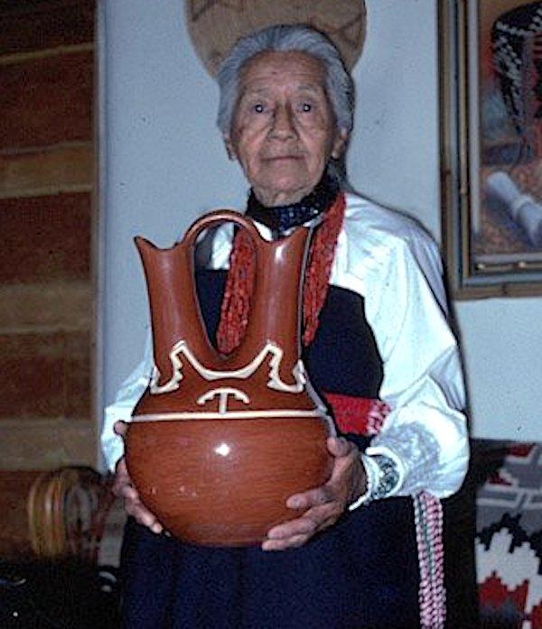 A woman holding a clay pot.