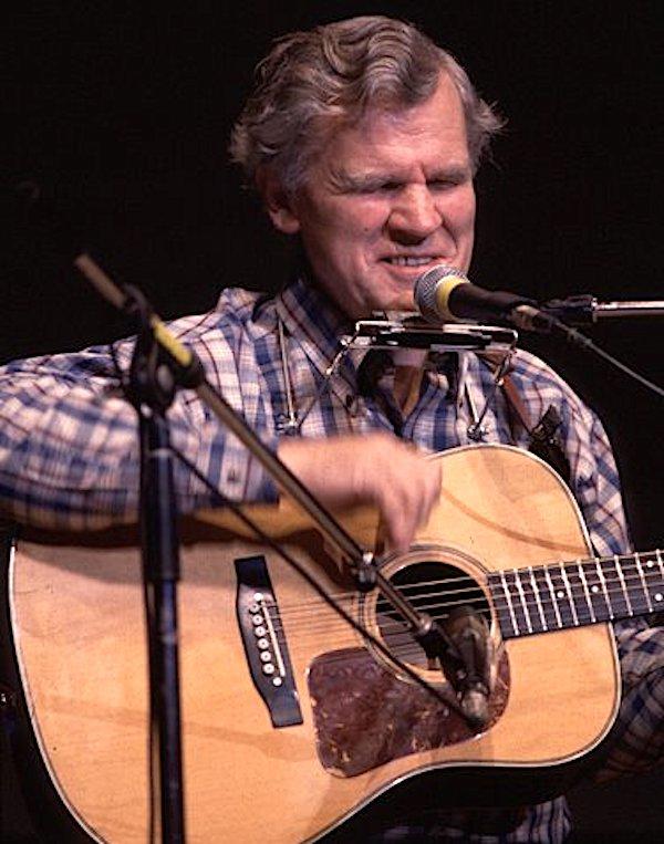 A man playing a guitar on stage.