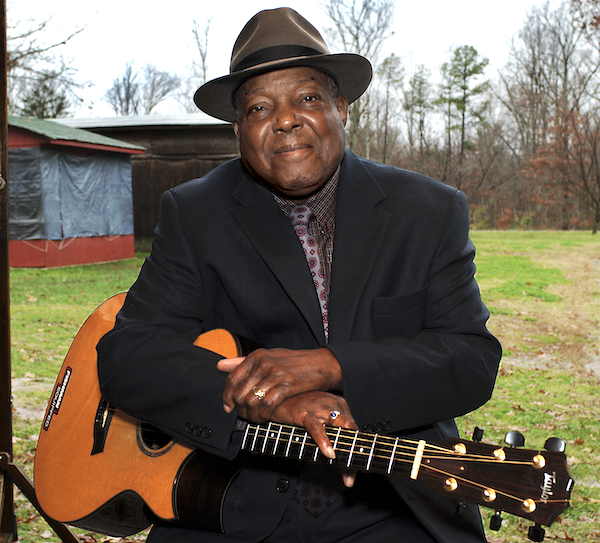 A man holding a guitar.