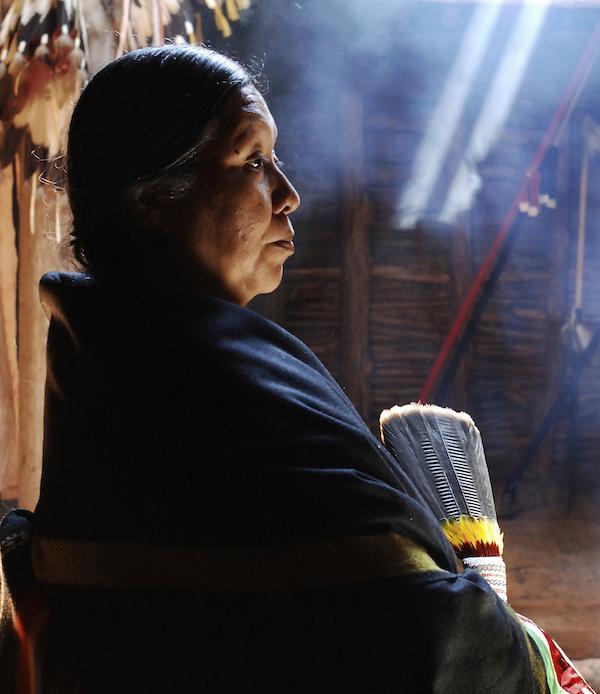 A woman shrouded in a native shawl seen in profile.