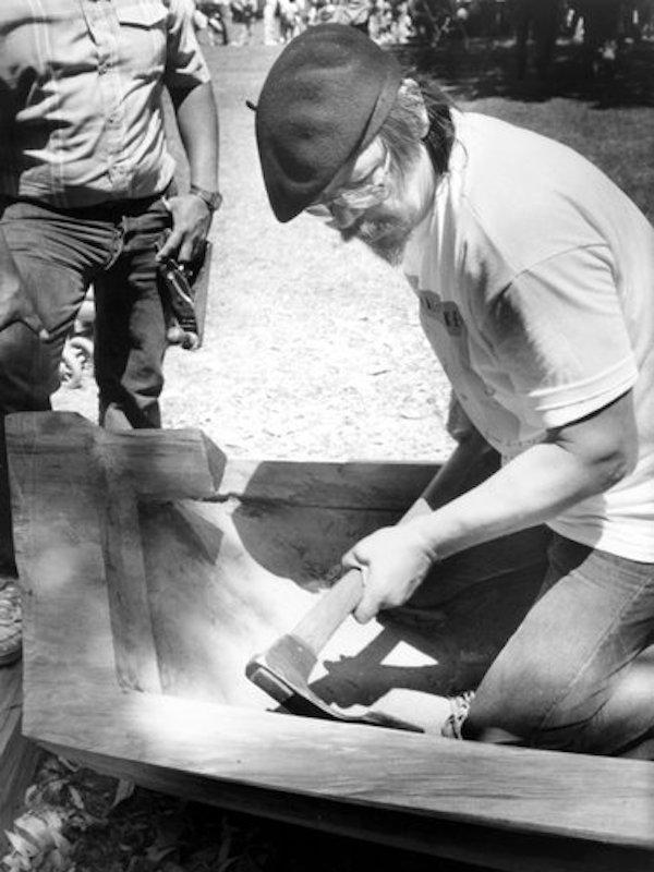 A man carving a canoe.