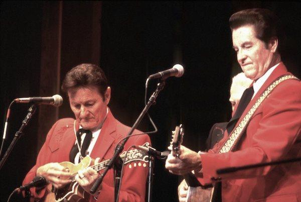 Two men on stage playing their instruments.