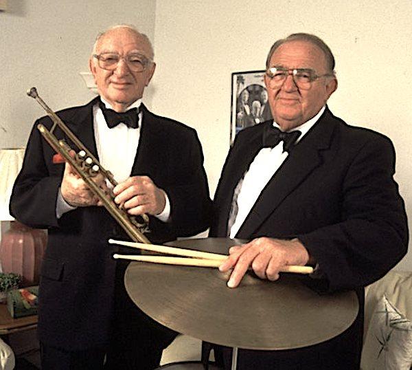 Two men dfressed in suits.