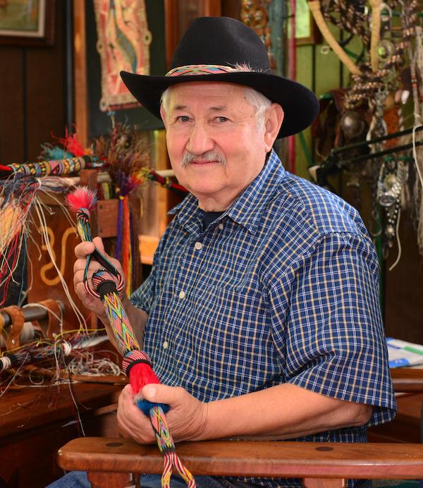 A man holding a leather whip.