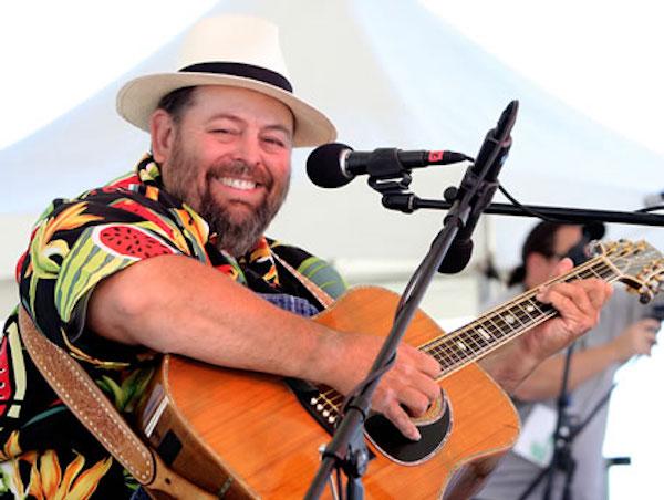 A man playing the guitar onstage.