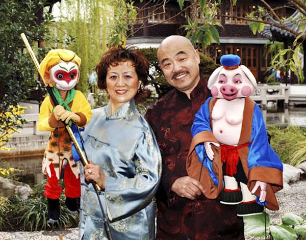 A man and a woman holding puppets.