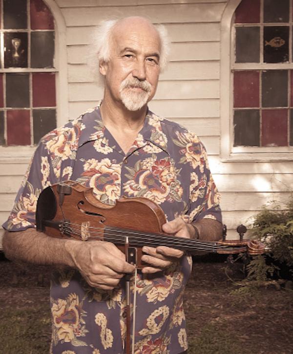 A man poses holding a mandolin.