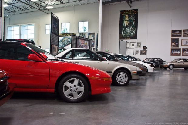 Three old style Toyota cars lined parked inside the museum.xxx